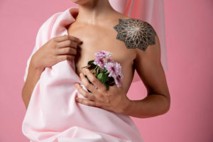בחורה מחזיקה פרח ומסתירה את השד